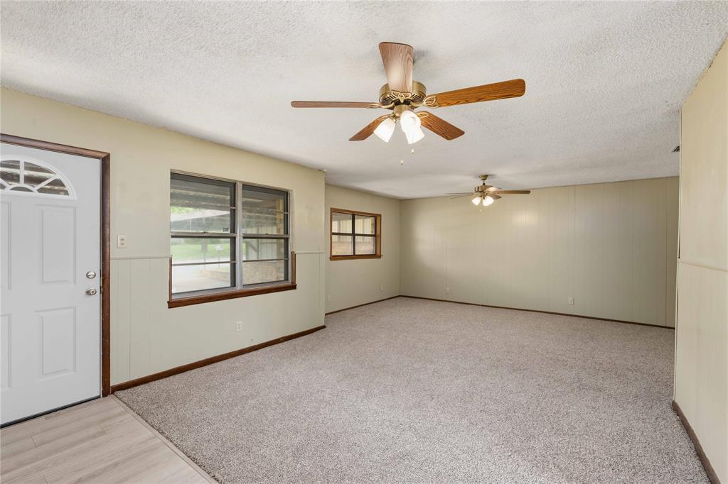 900 West 2nd Street Coleman, TX 76834 - Photo 4 of 28 an empty room with windows and ceiling fan
