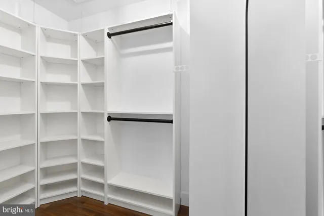 a view of a kitchen with refrigerator and wooden floor