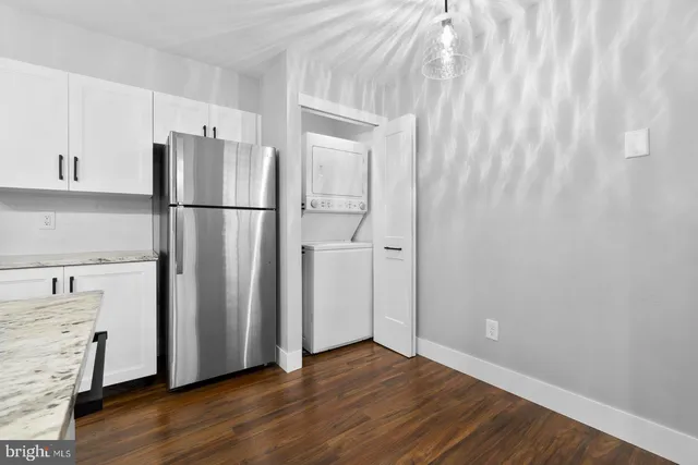 a kitchen with stainless steel appliances granite countertop a refrigerator a stove and a sink