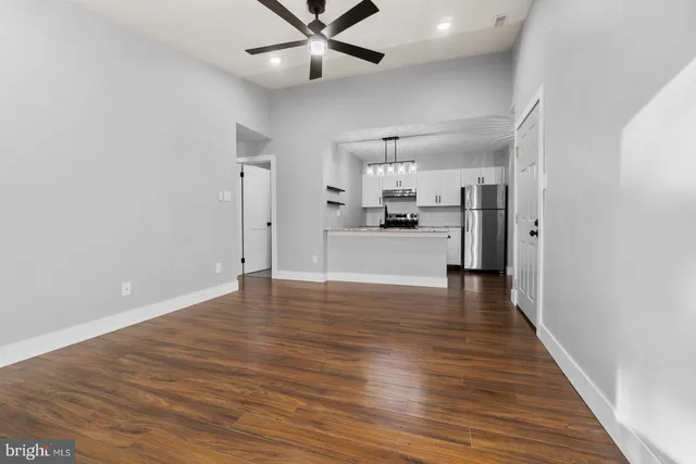 a view of a kitchen with a refrigerator and wooden floor