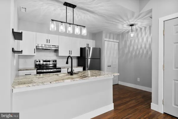 a kitchen with stainless steel appliances a sink stove and refrigerator