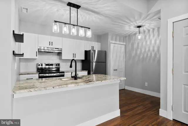 a kitchen with stainless steel appliances a sink stove and refrigerator