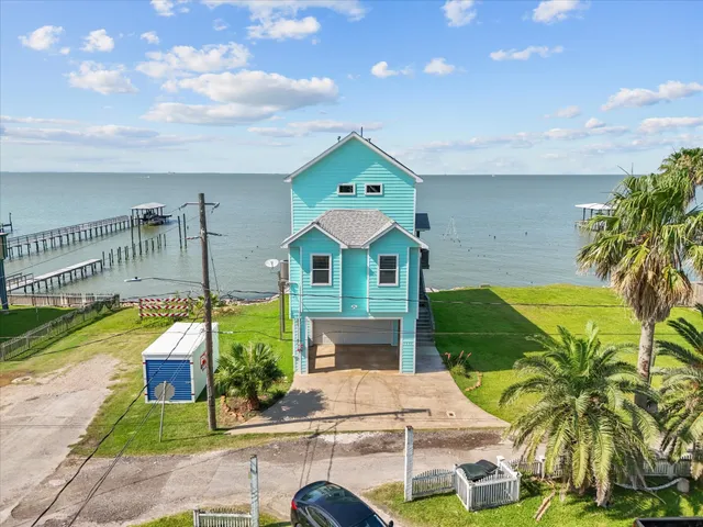 a front view of a house with a yard and potted plants