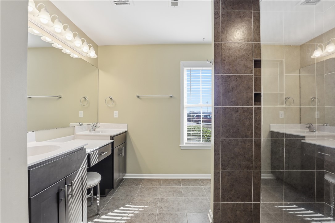 202 C-1-231 Pelzer, SC 29669 - Photo 16 of 49 This spacious bathroom offers dual vanities, a tiled shower, and a bright window.