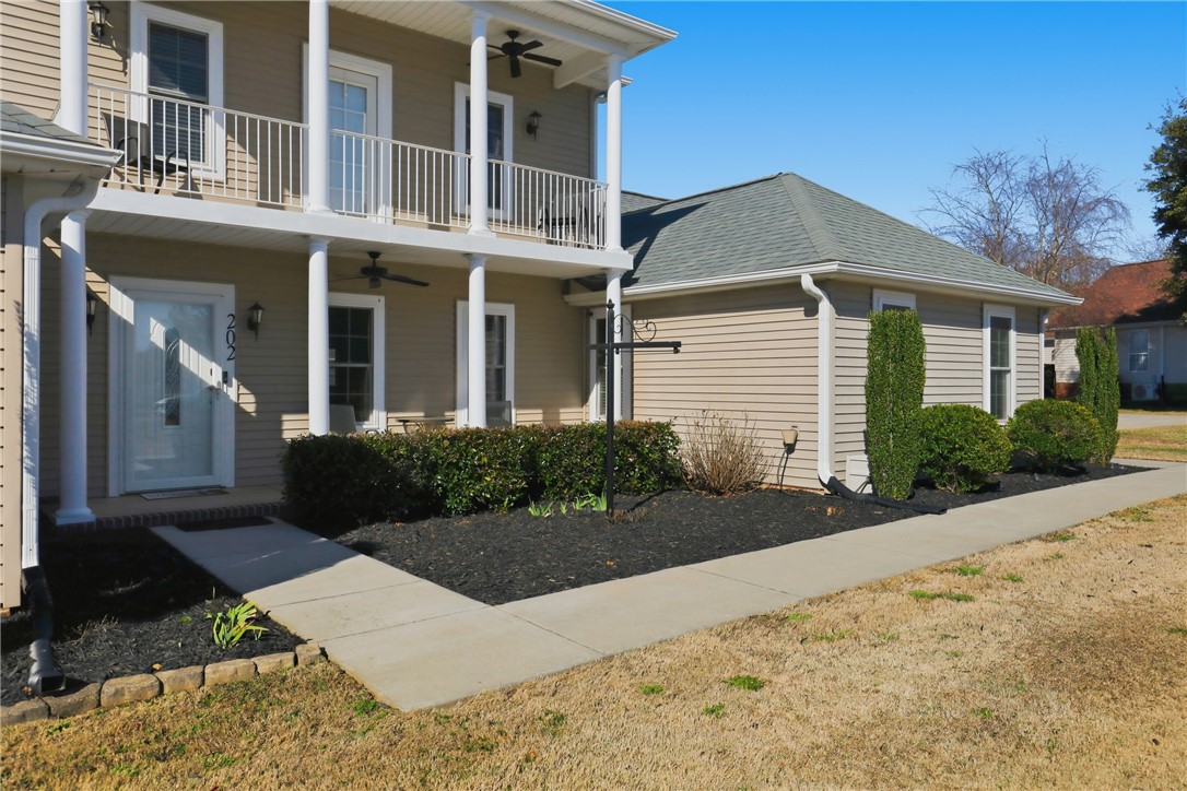 202 C-1-231 Pelzer, SC 29669 - Photo 2 of 49 This residence features a welcoming facade with a balcony, classic siding, and manicured landscaping.