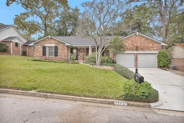 a front view of a house with a garden and trees