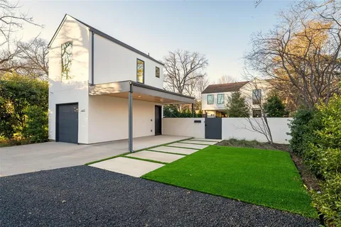 a view of a white house with a yard and large tree