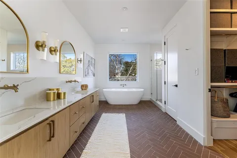 a spacious bathroom with a double vanity sink a mirror and a bathtub