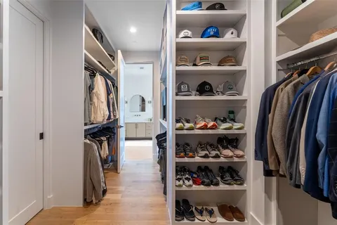 a view of walk in closet with clothes and shoes