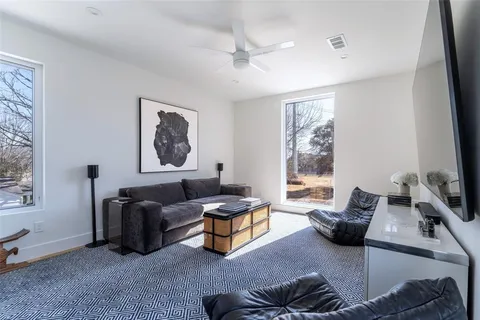 a living room with furniture ceiling fan and a window