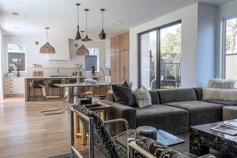 a living room with furniture kitchen and a large window