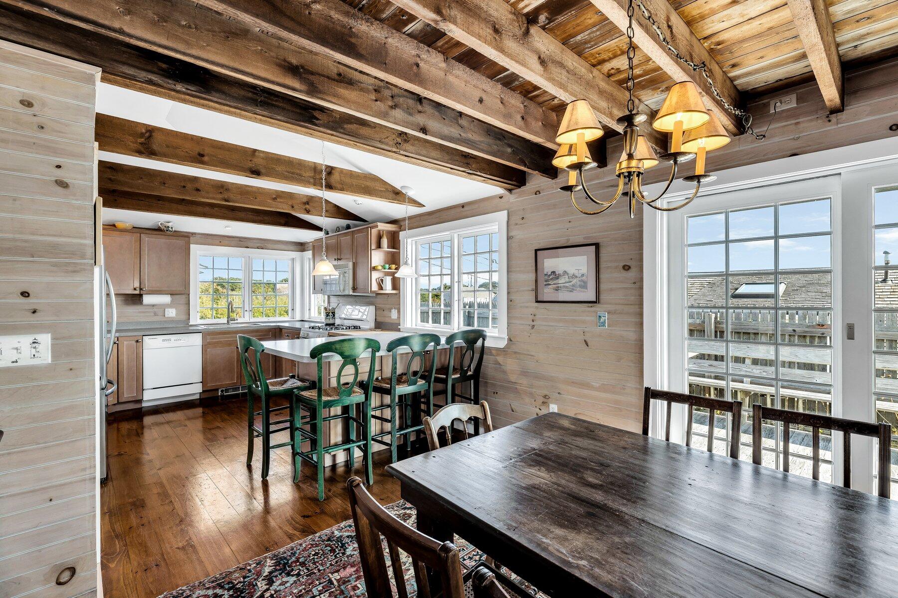 6 Bay View Path Truro, MA 02666 - Photo 33 of 57 a dining room with wooden floor a chandelier a wooden table and chairs