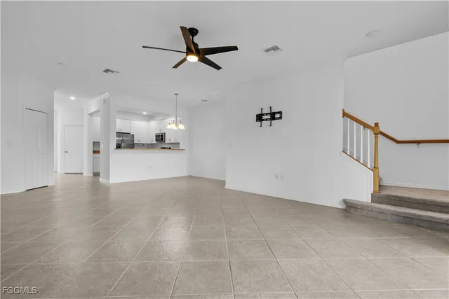 a view of a livingroom with a ceiling fan a ceiling fan and kitchen view