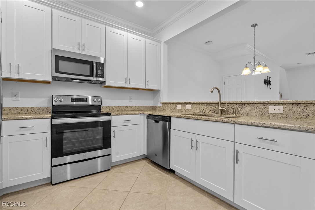 12557 Westhaven Way Fort Myers, FL 33913 - Photo 5 of 24 a kitchen with granite countertop white cabinets white stainless steel appliances and a sink