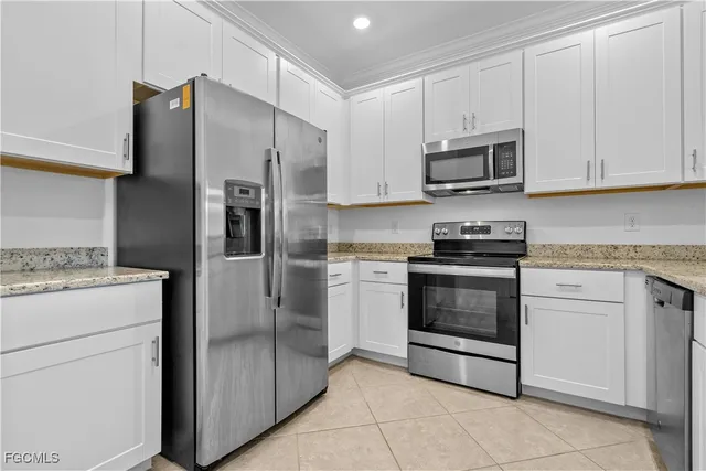 a kitchen with white cabinets and stainless steel appliances