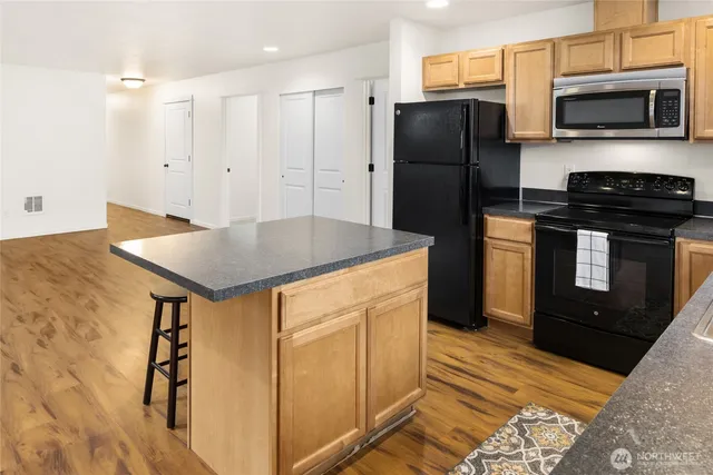 a kitchen with stainless steel appliances granite countertop a refrigerator a stove and a sink