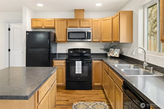 a kitchen with stainless steel appliances granite countertop a sink a stove and a refrigerator