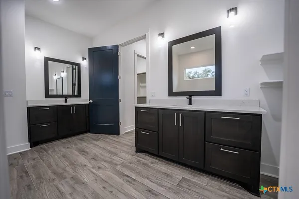 a bathroom with a vanity a sink a mirror and a toilet