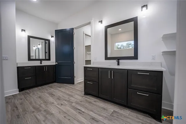 a bathroom with a vanity a sink a mirror and a toilet