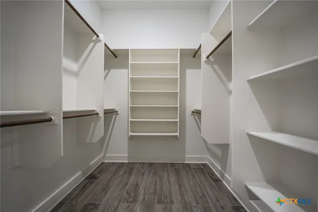 a view of walk in closet with empty racks