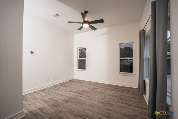 a view of empty room with wooden floor