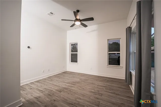 a view of empty room with wooden floor