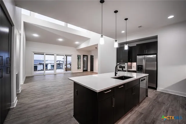 a kitchen with kitchen island a sink stove and wooden floor