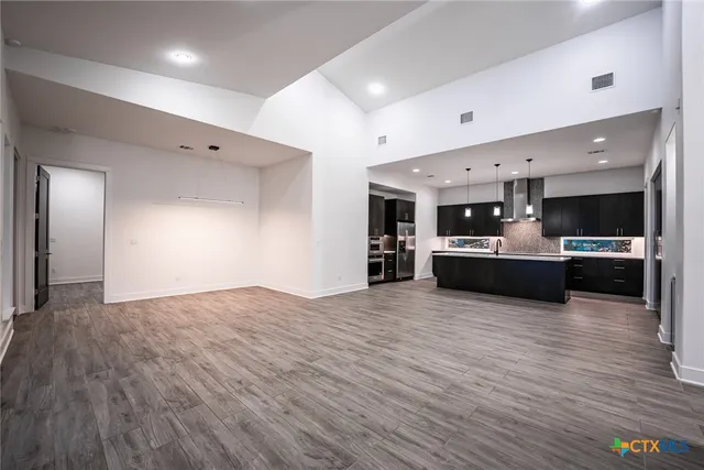 a kitchen with stainless steel appliances kitchen island granite countertop a stove and a refrigerator
