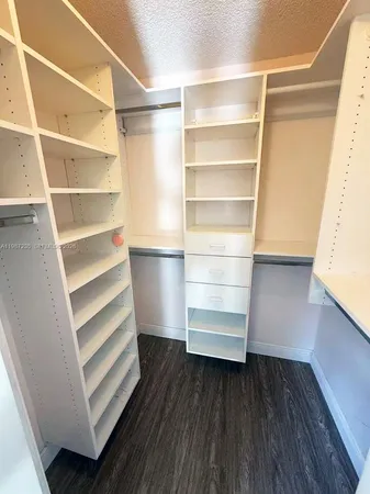 a view of walk in closet with empty racks