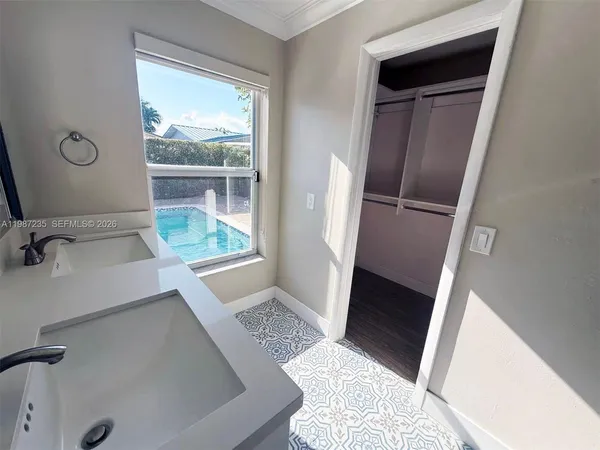 a view of bathroom with a sink and mirror