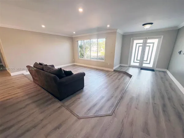 a living room with furniture and wooden floor