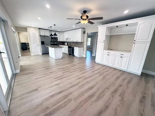 a view of kitchen with stainless steel appliances refrigerator stove microwave and cabinets