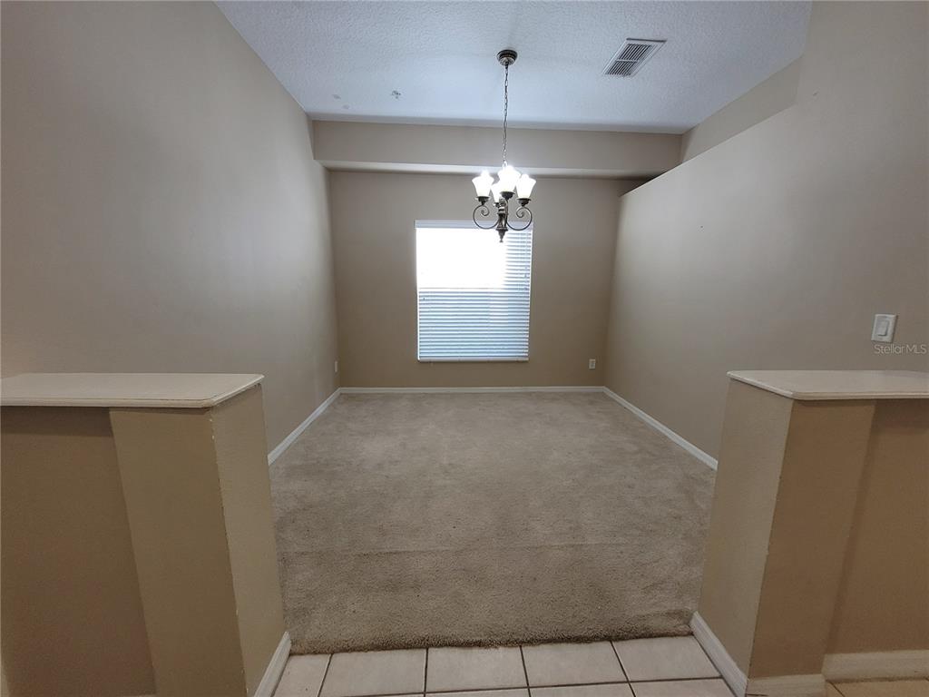 673 Sandy Neck Lane, Unit 101 Altamonte Springs, FL 32714 - Photo 13 of 39 en empty room with windows and chandelier fan