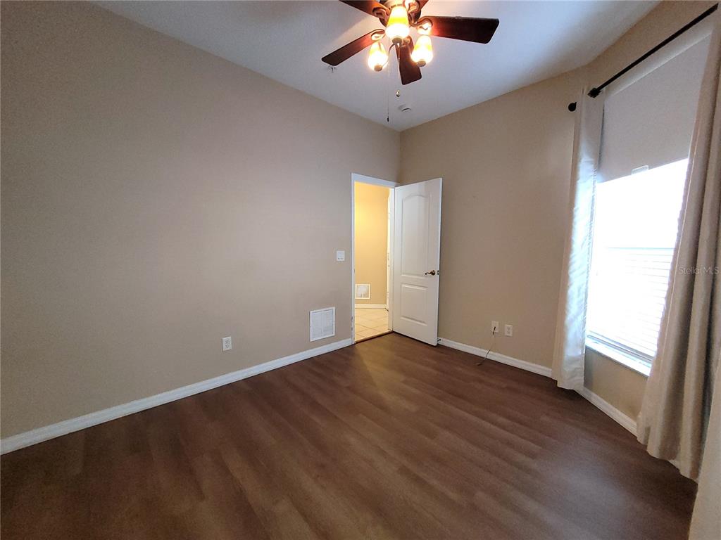 673 Sandy Neck Lane, Unit 101 Altamonte Springs, FL 32714 - Photo 22 of 39 an empty room with wooden floor and chandelier fan
