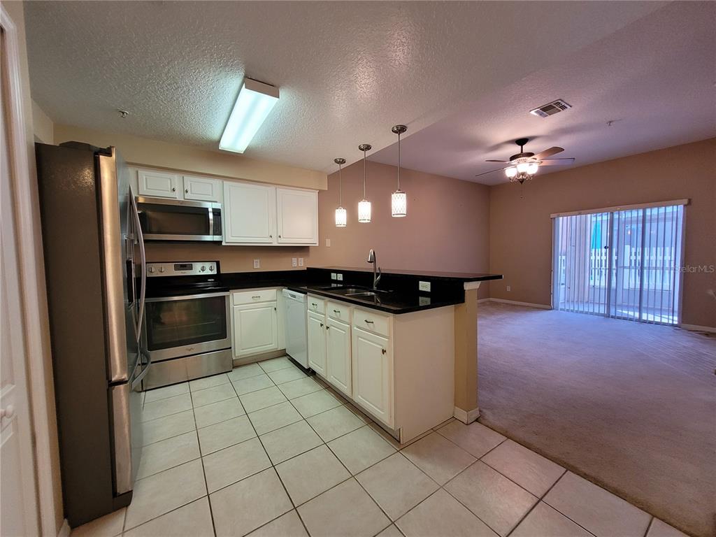 673 Sandy Neck Lane, Unit 101 Altamonte Springs, FL 32714 - Photo 5 of 39 a kitchen with a refrigerator a sink and cabinets