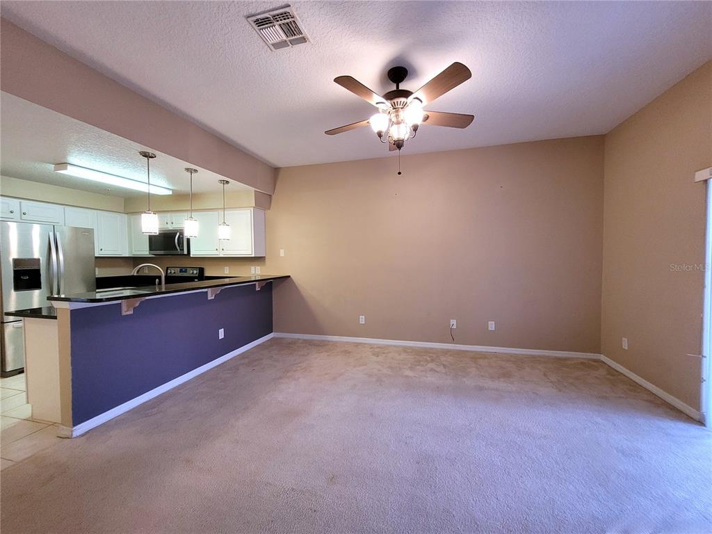 673 Sandy Neck Lane, Unit 101 Altamonte Springs, FL 32714 - Photo 10 of 39 a kitchen with stainless steel appliances kitchen island granite countertop a refrigerator a sink and dishwasher with wooden floor