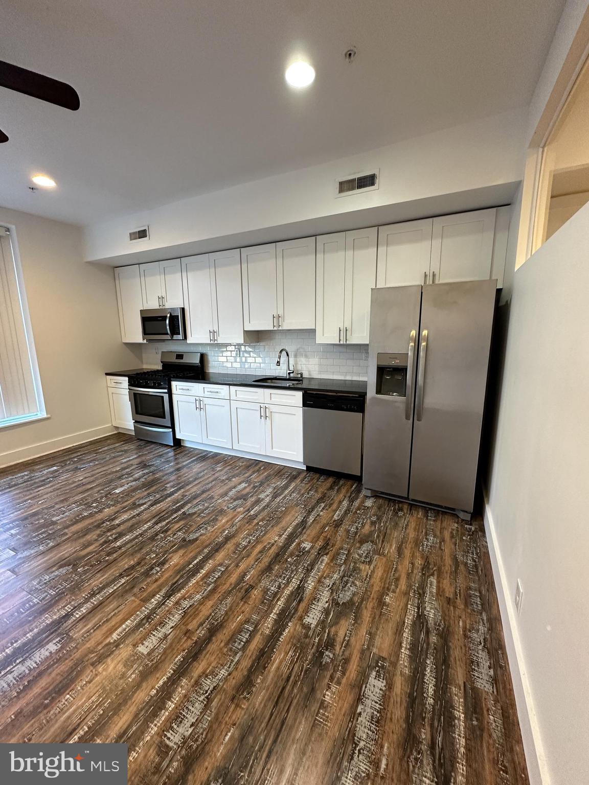 a kitchen with stainless steel appliances granite countertop a refrigerator stove microwave and sink