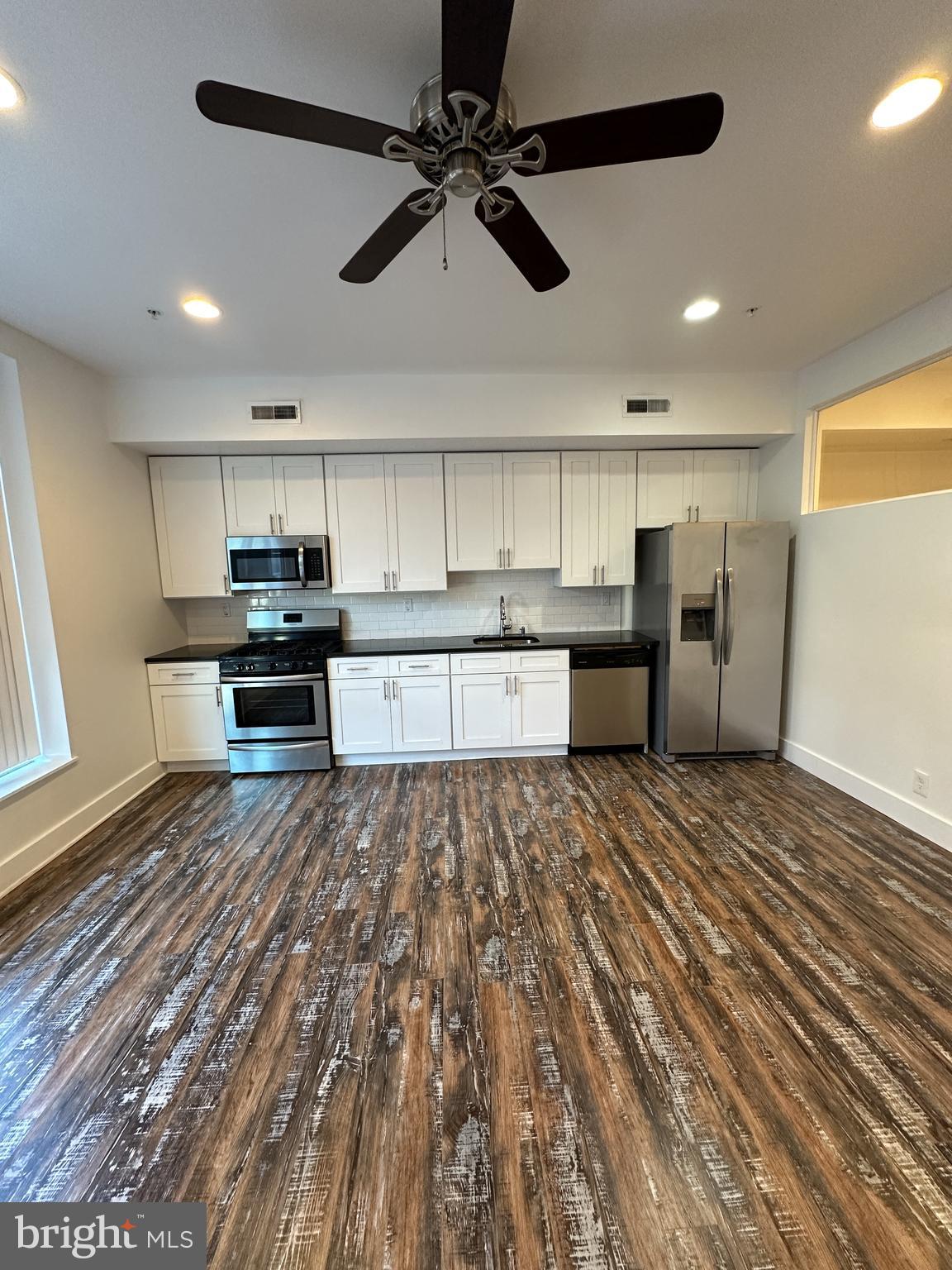 2206 North Front Street, Unit 2B Philadelphia, PA 19133 - Photo 2 of 28 a large kitchen with stainless steel appliances granite countertop a refrigerator and a stove top oven