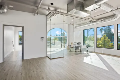 a dining room with wooden floor and a chandelier