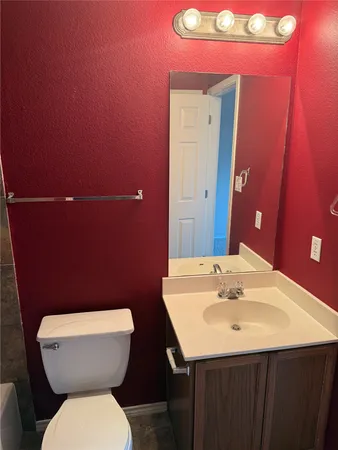 a bathroom with a toilet a sink and mirror