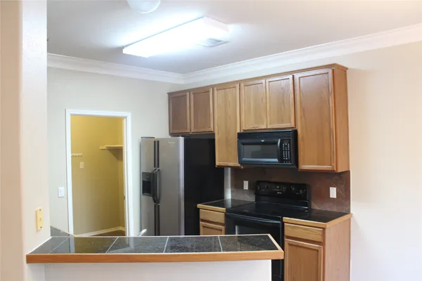 a kitchen with stainless steel appliances wooden cabinets and a refrigerator