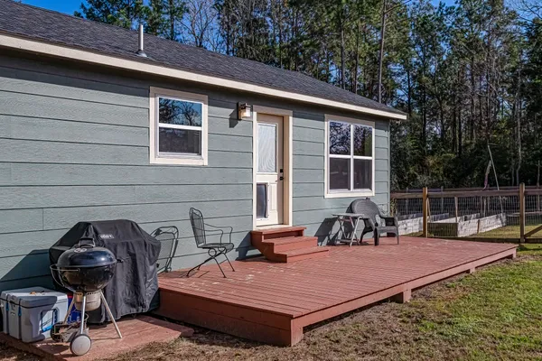 a view of a house with a yard balcony and wooden fence