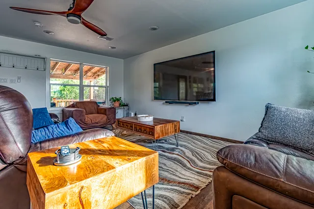 a living room with furniture a flat screen tv and a window