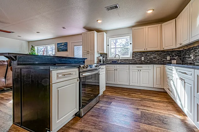 a kitchen with granite countertop a sink and a stove top oven