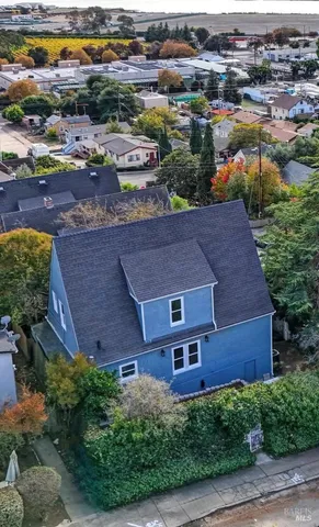 an aerial view of residential houses with outdoor space and parking