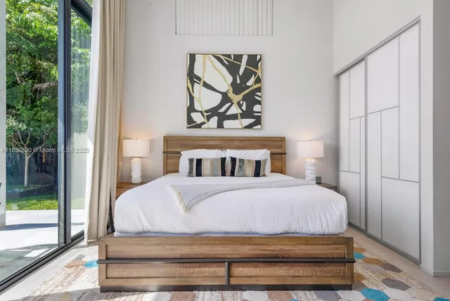 a bedroom with furniture and a large window