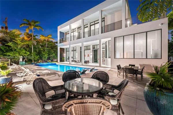 a view of a house with swimming pool and sitting area