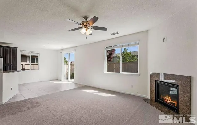 a view of an empty room with window and fire place