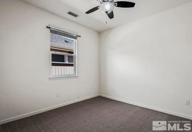 an empty room with chandelier fan