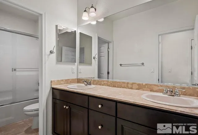 a bathroom with a double vanity sink toilet and shower